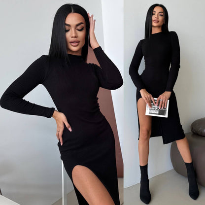 Woman wearing a black long-sleeve dress with a slit, posing indoors.
