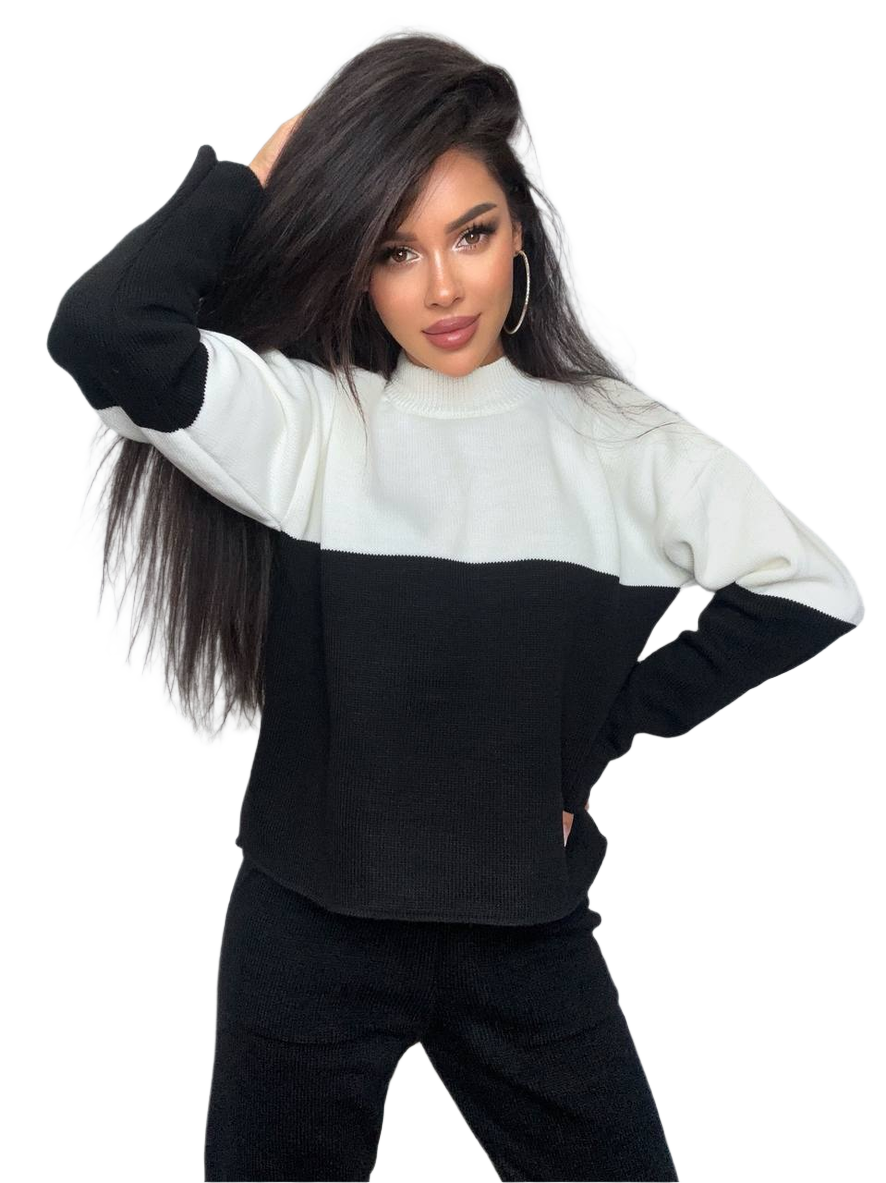 Woman wearing a black and white color-blocked sweater on a white background