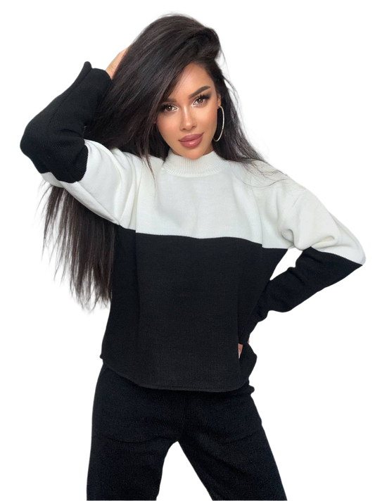 Woman wearing a black and white color-blocked sweater on a white background