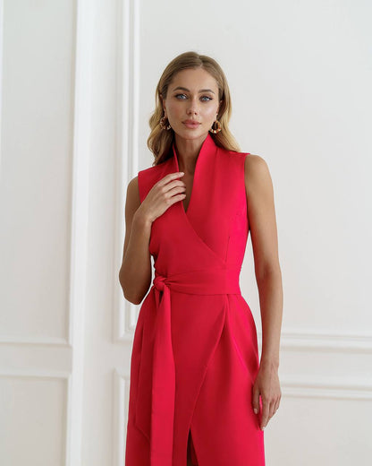 Woman wearing a red sleeveless dress against a white wall