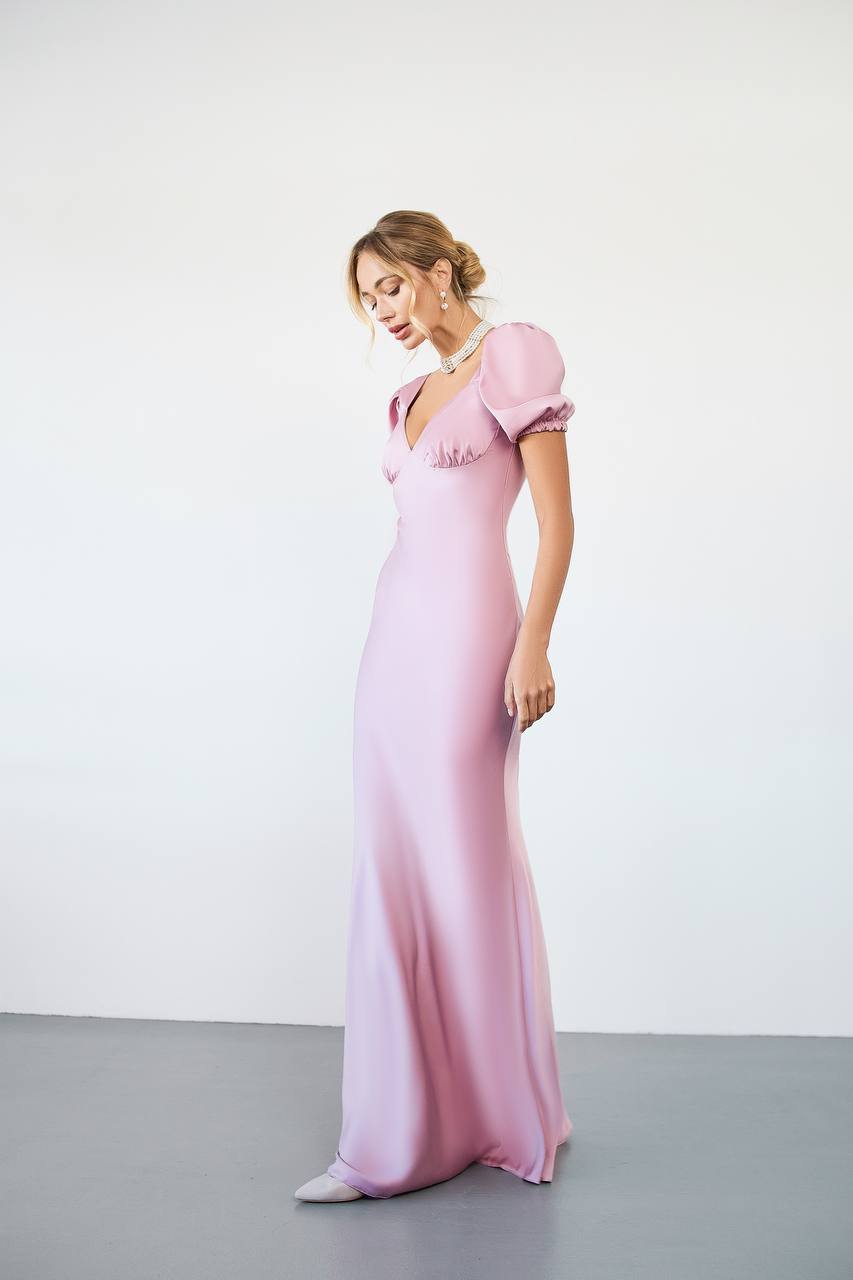 Woman wearing a pink evening gown against a white background