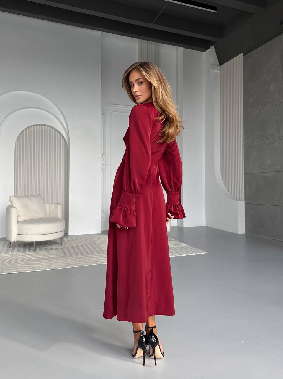 Woman in a red dress standing in a modern indoor setting