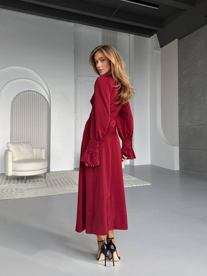 Woman in a red dress standing in a modern indoor setting