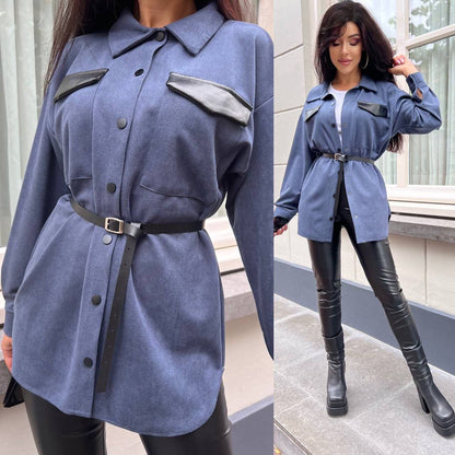 Woman wearing a blue coat with black accents and black leather pants outdoors.