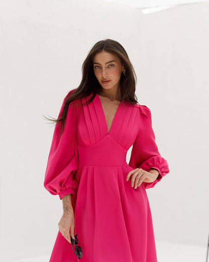 Woman wearing a bright pink dress against a white background
