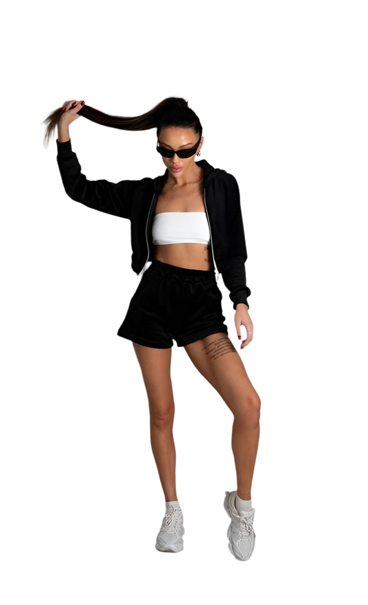 Woman in black hoodie, shorts, and white top with sunglasses on a white background