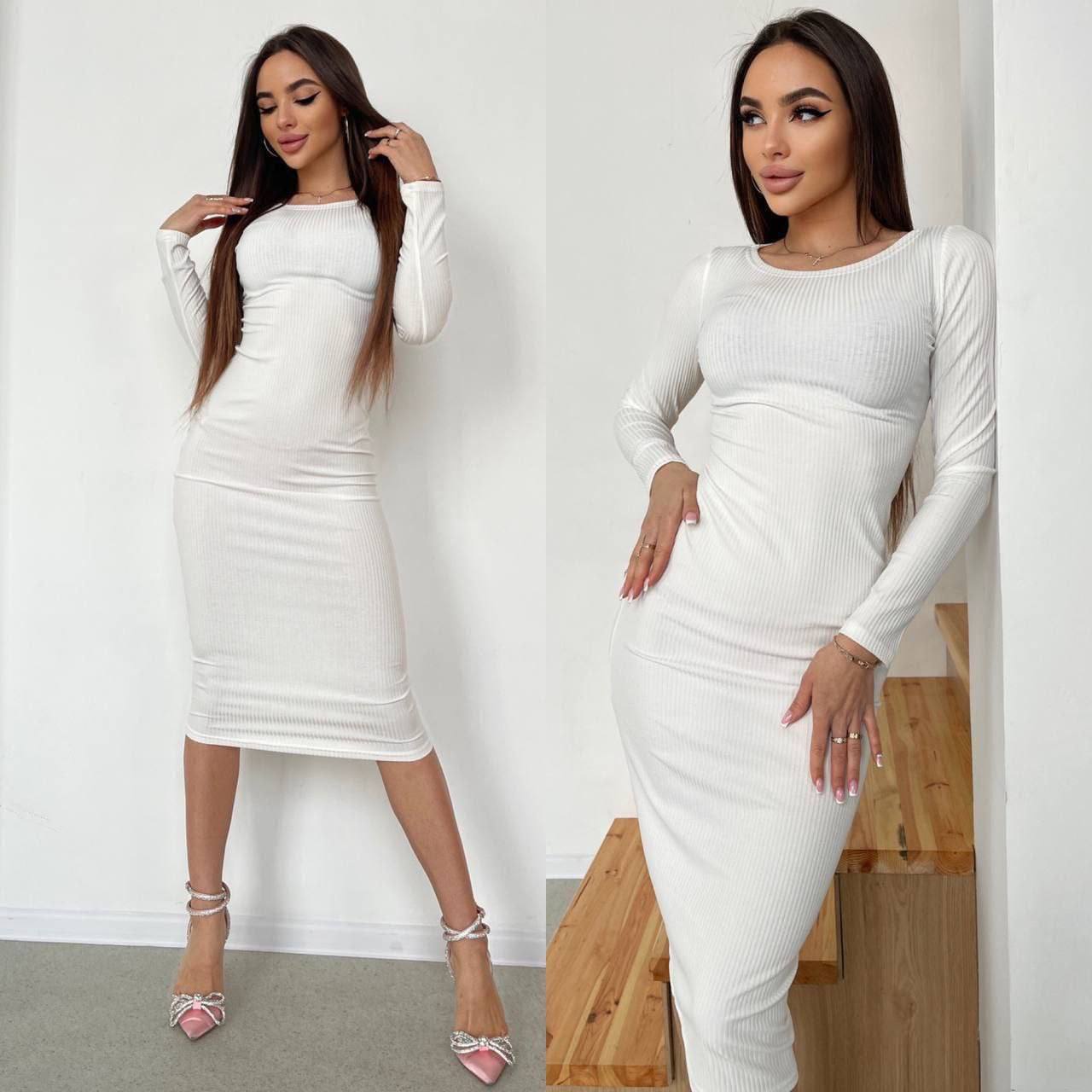 Two women wearing white long-sleeve dresses posing against a plain background.