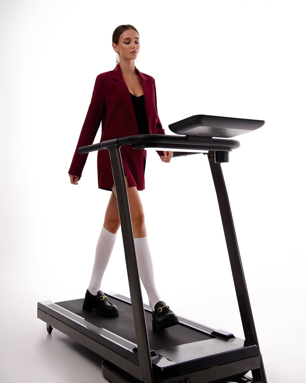 Woman using a treadmill with a white background