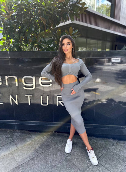 Woman in gray athletic wear posing in front of a building with 'Venture' branding.