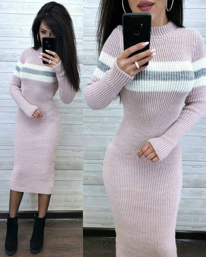 Woman wearing a pink ribbed dress with white and gray stripes, taking a mirror selfie.