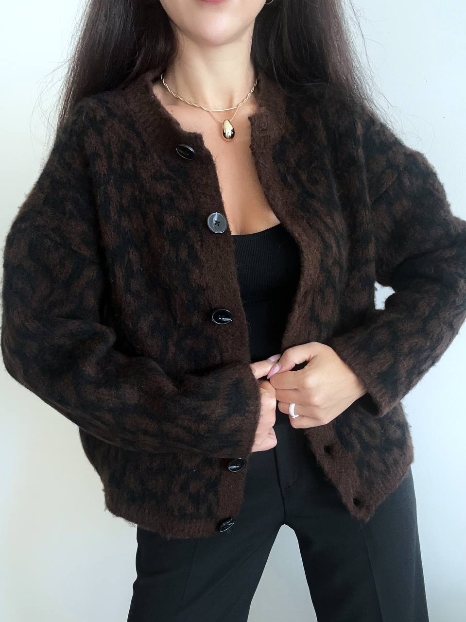 Person wearing a brown leopard print jacket against a white background