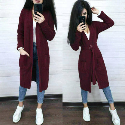 Person wearing a burgundy cardigan, white shirt, blue jeans, and white sneakers, taking a mirror selfie.