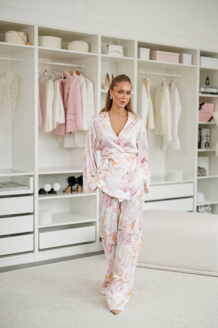 Woman in a floral robe standing in a well-organized wardrobe.