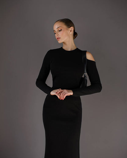 Woman wearing a black dress against a gray background