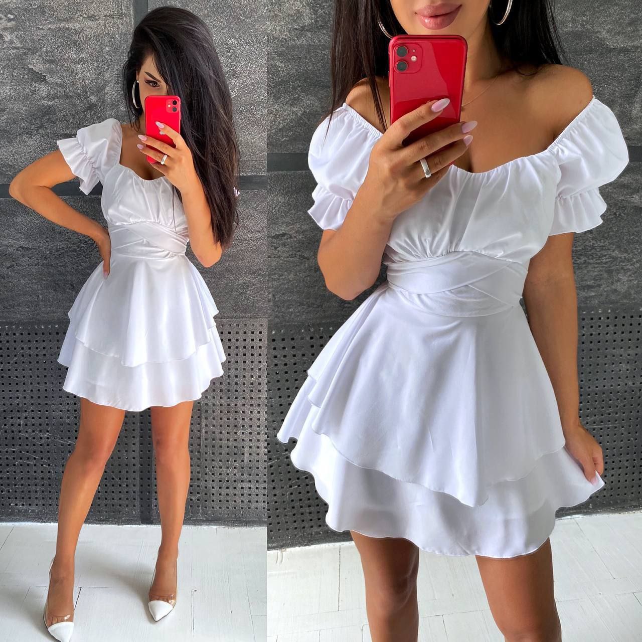 Woman wearing a white off-shoulder dress with ruffled sleeves and skirt, holding a red phone.