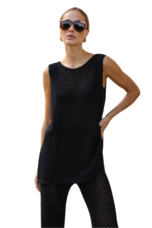 Woman wearing a black sleeveless top and pants on a white background