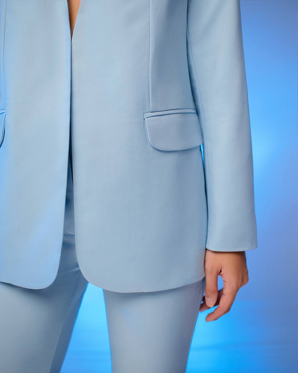 Light blue suit jacket and pants on a gradient blue background