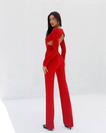 Woman wearing a red jumpsuit with cut-out design on a white background