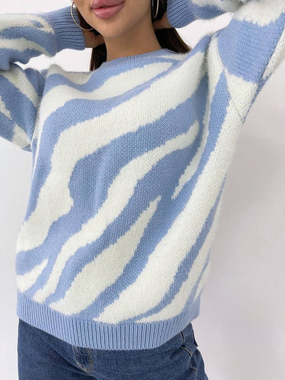 Person wearing a blue and white patterned sweater with a plain background