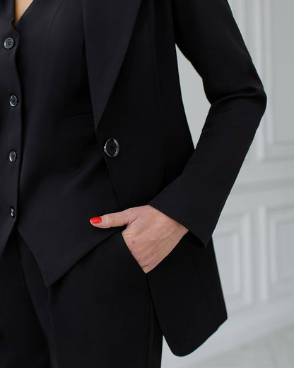 Person wearing a black suit with a blurred background