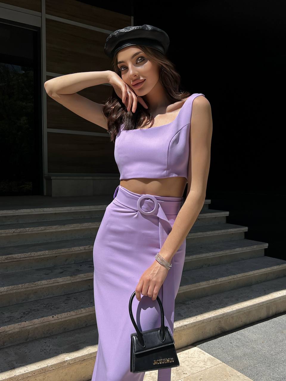 Woman in a lavender outfit standing on steps outdoors