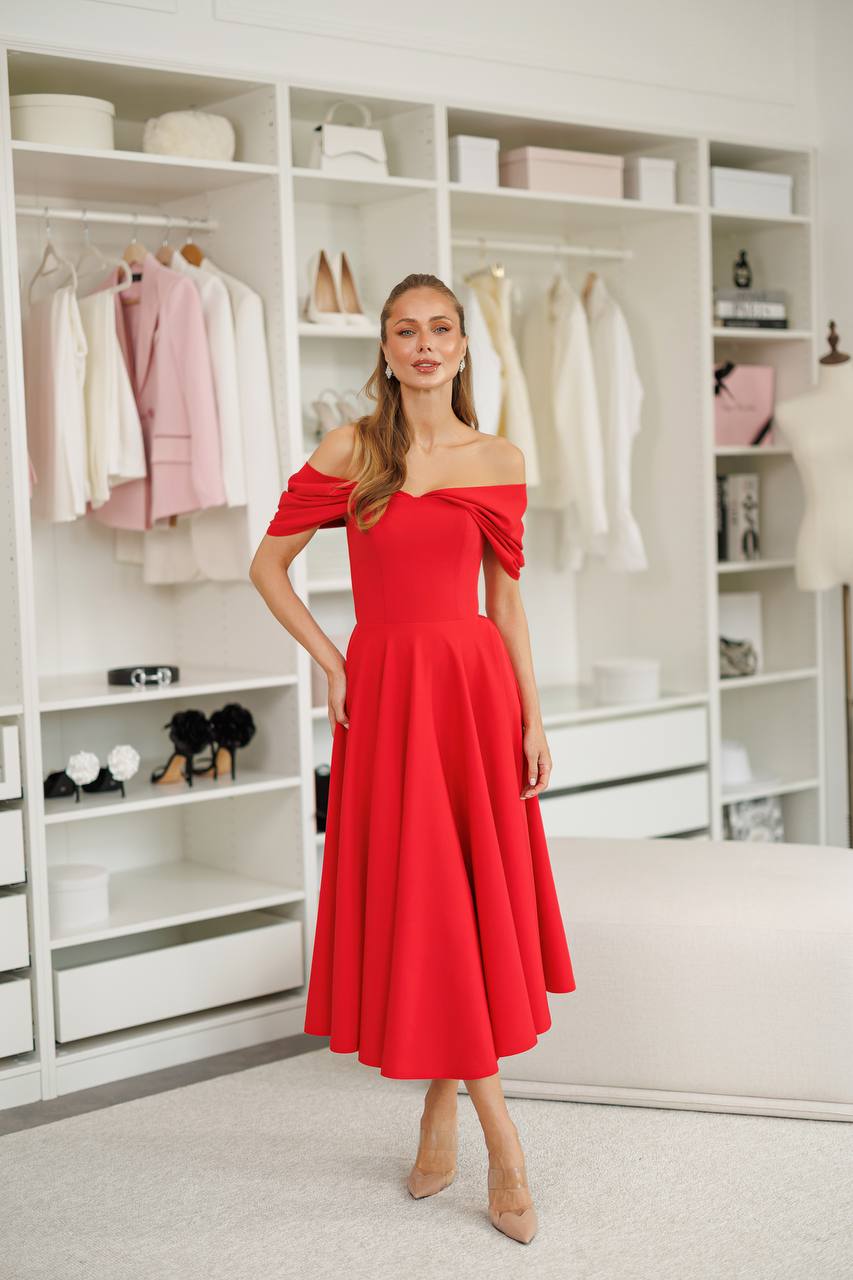 Woman in a red off-shoulder dress standing in a well-organized wardrobe.