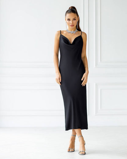Woman wearing a black slip dress against a white background