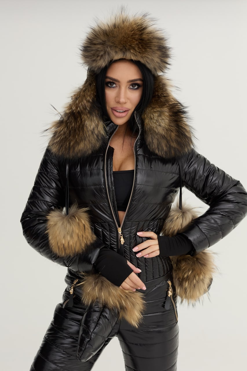 Person wearing a black leather jacket with fur trim on a plain background