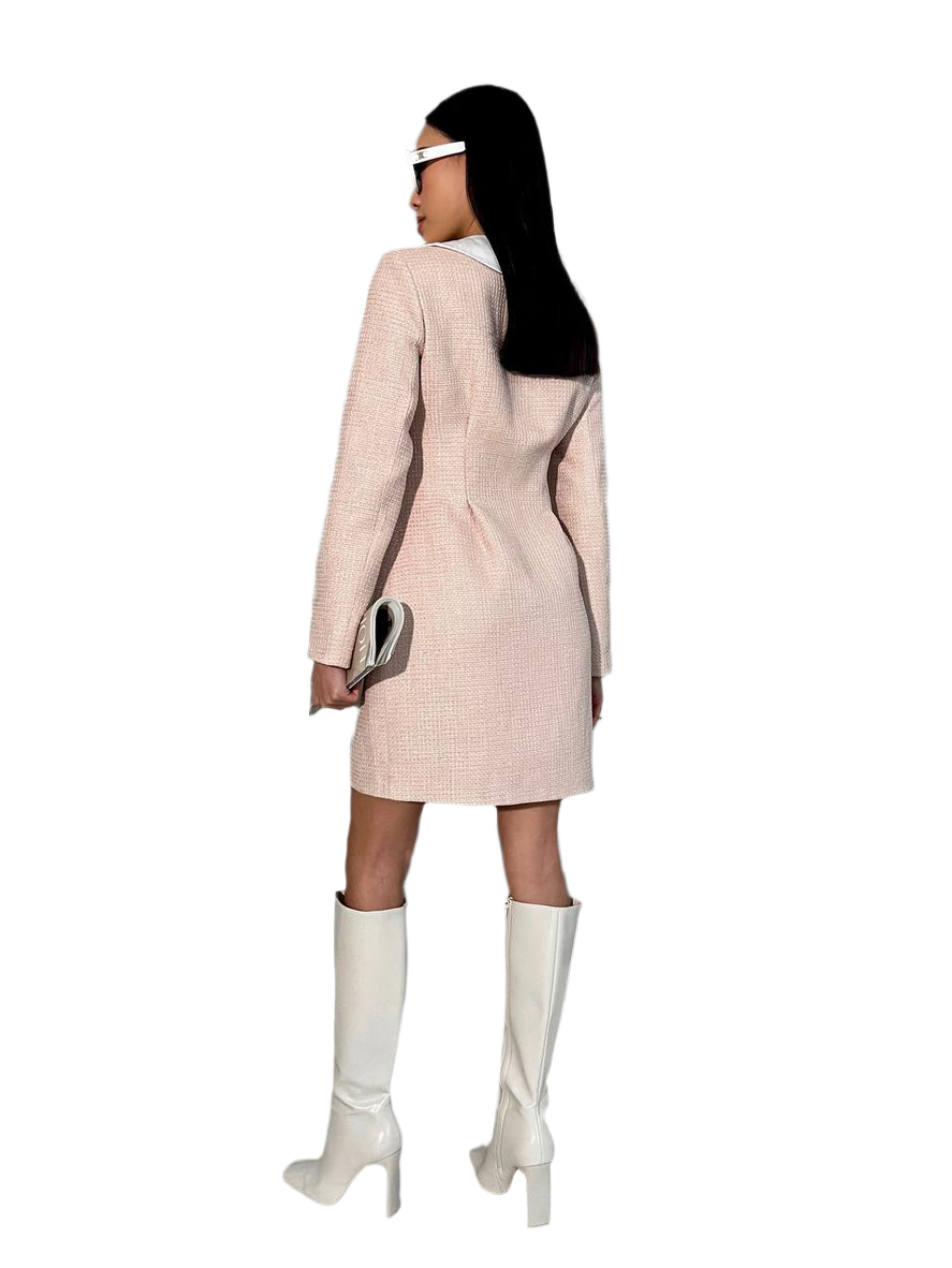 Person wearing a light pink coat and white knee-high boots on a white background