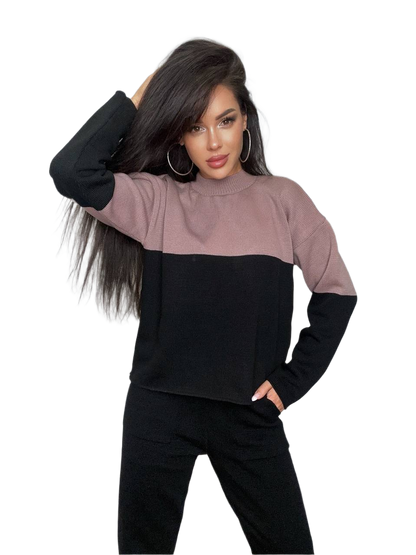 Woman wearing a two-tone black and pink sweater on a white background