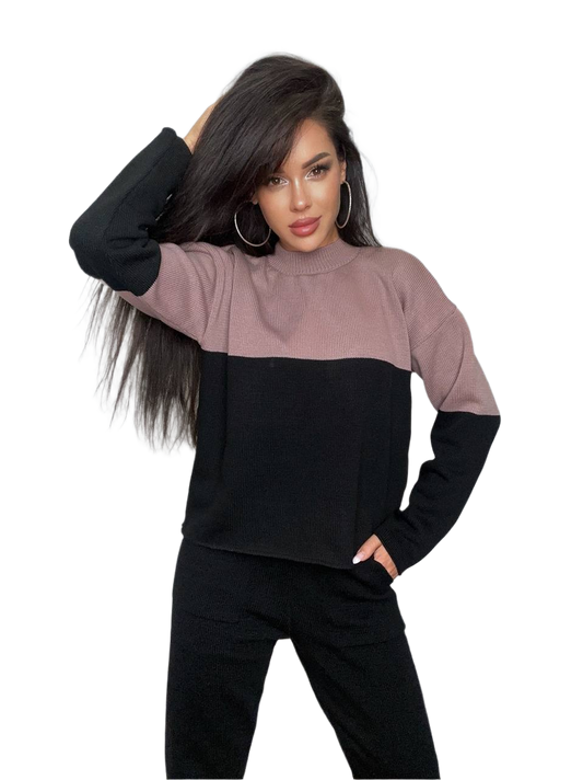 Woman wearing a two-tone black and pink sweater on a white background