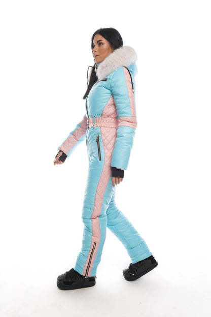 Woman wearing a light blue and pink ski suit on a white background