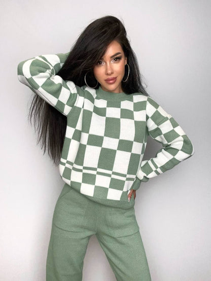 Woman wearing a green and white checkered sweater against a plain background