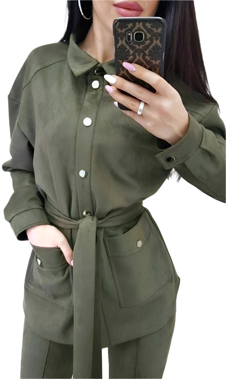 Person wearing a green outfit with a belt, holding a phone with a leopard print case.