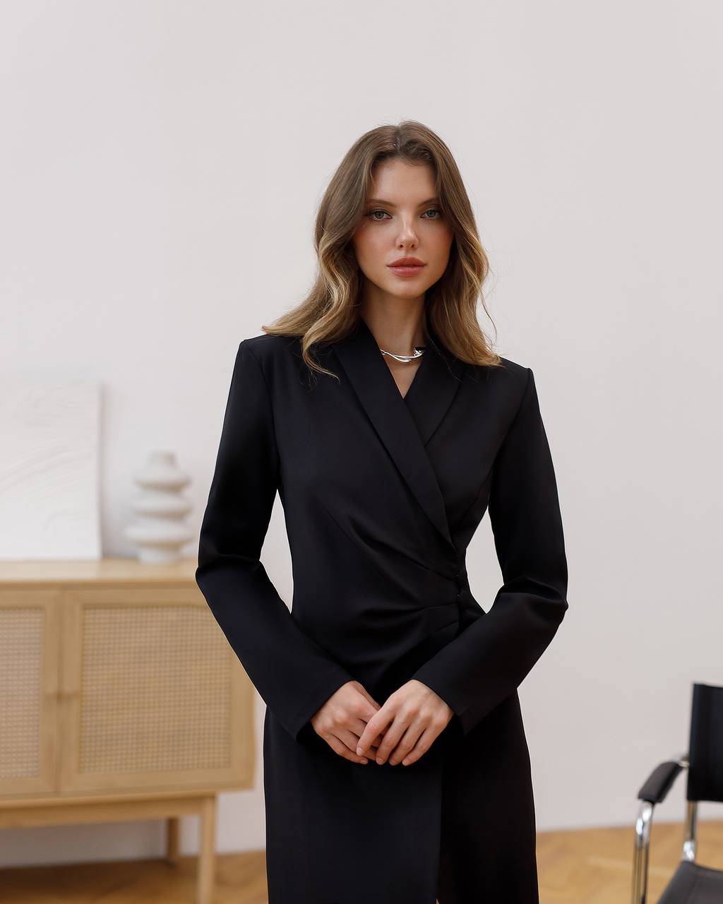 Woman wearing a black coat in an indoor setting