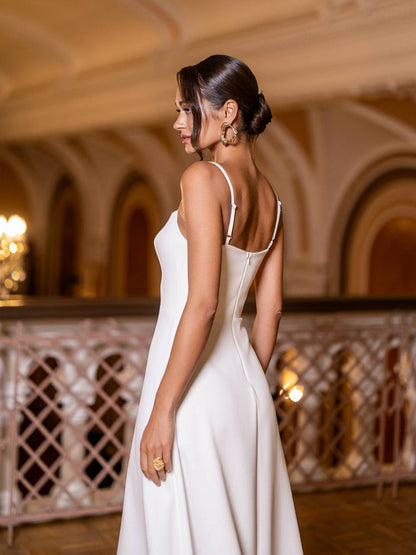 Woman in a white dress standing in an elegant indoor setting