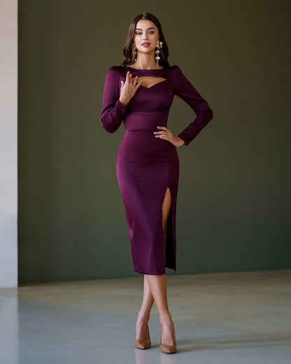Woman wearing a purple dress with a slit standing against a plain background
