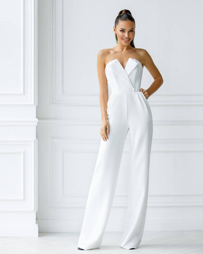 Woman wearing a strapless white jumpsuit against a white background