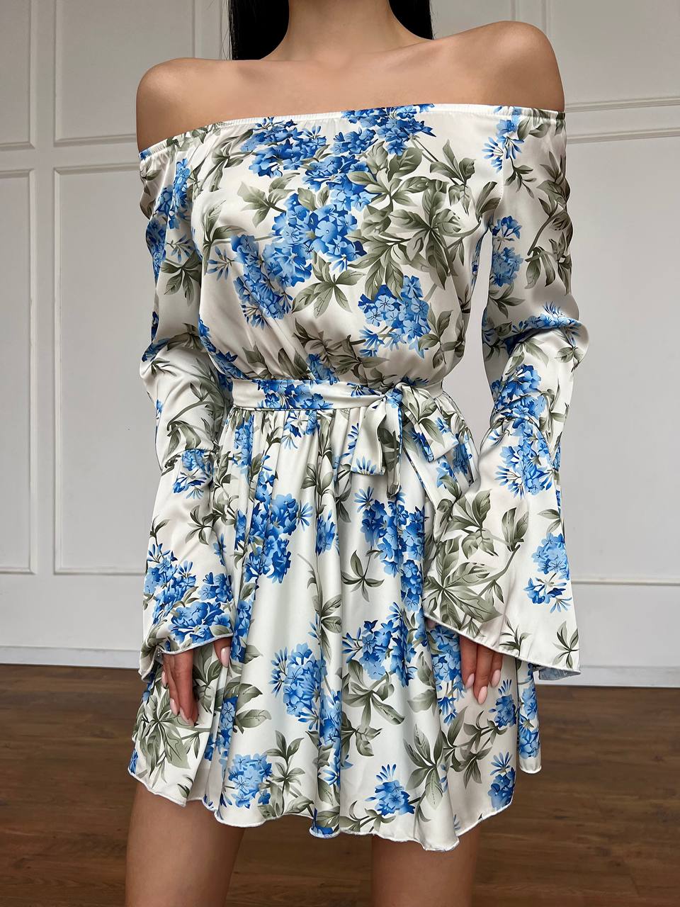 Floral off-shoulder dress with blue and green flowers on a white background
