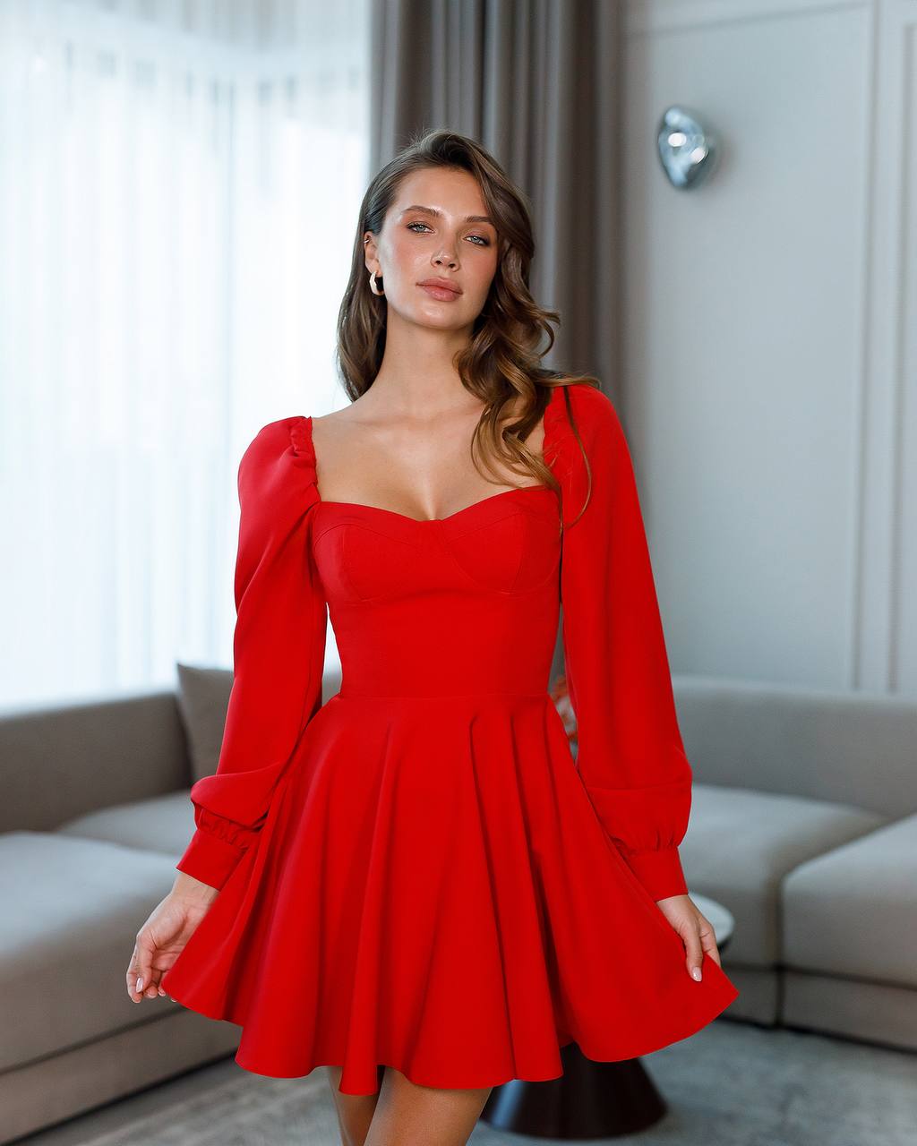 Woman wearing a red dress with long sleeves in an indoor setting