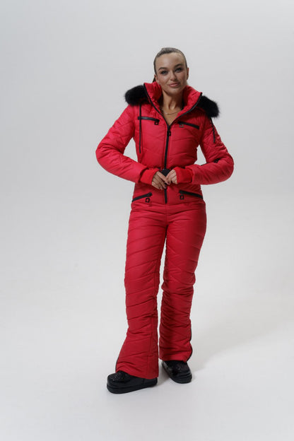 Person wearing a red snowsuit with black fur trim on a white background
