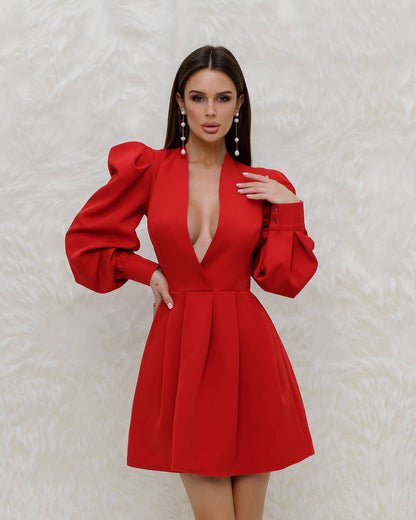 Woman wearing a red dress with puffed sleeves against a textured white background