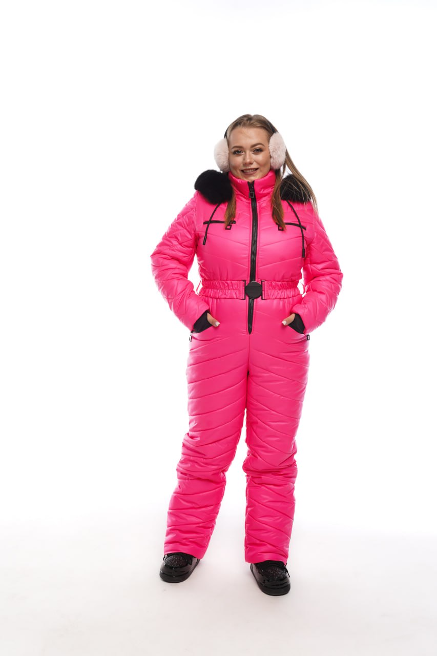 Person wearing a bright pink snowsuit with black boots on a white background