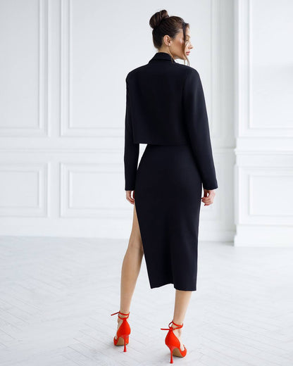 Woman wearing a black outfit with a high slit and red shoes in a minimalistic setting