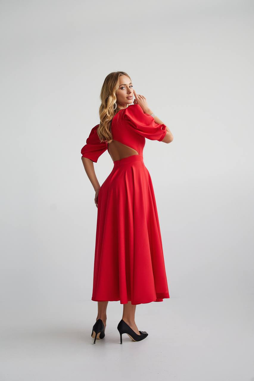 Woman wearing a red dress with cut-out design on a white background