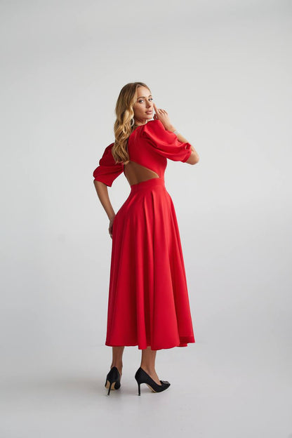 Woman wearing a red dress with cut-out design on a white background