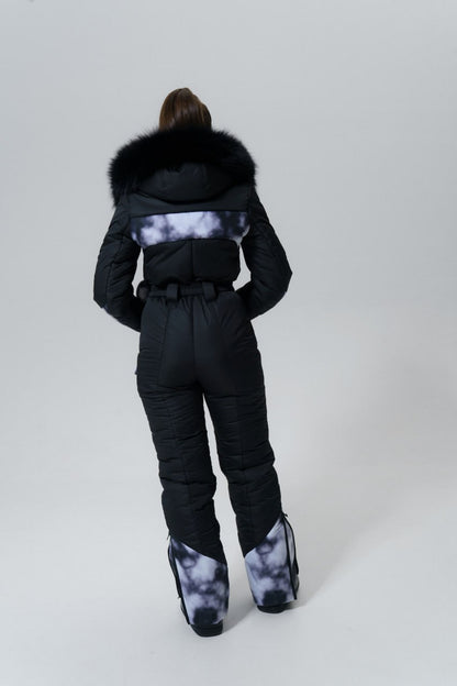 Person wearing a black snowsuit with fur hood on a white background