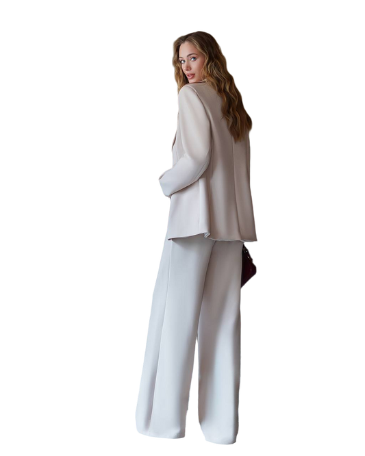 Woman wearing a beige blazer and white pants on a white background