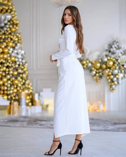 Woman in a white dress standing in a decorated room with Christmas trees.