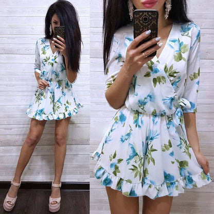 Woman wearing a floral dress taking a mirror selfie against a wooden panel background